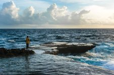 Youngmanstandinginfrontofragingseaandbreakingwaves Kopie.jpg